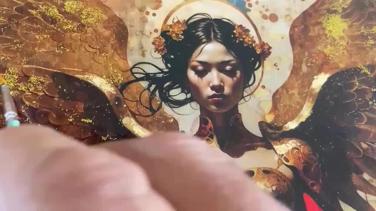 A hand applying gold leaf detail to a painted portrait